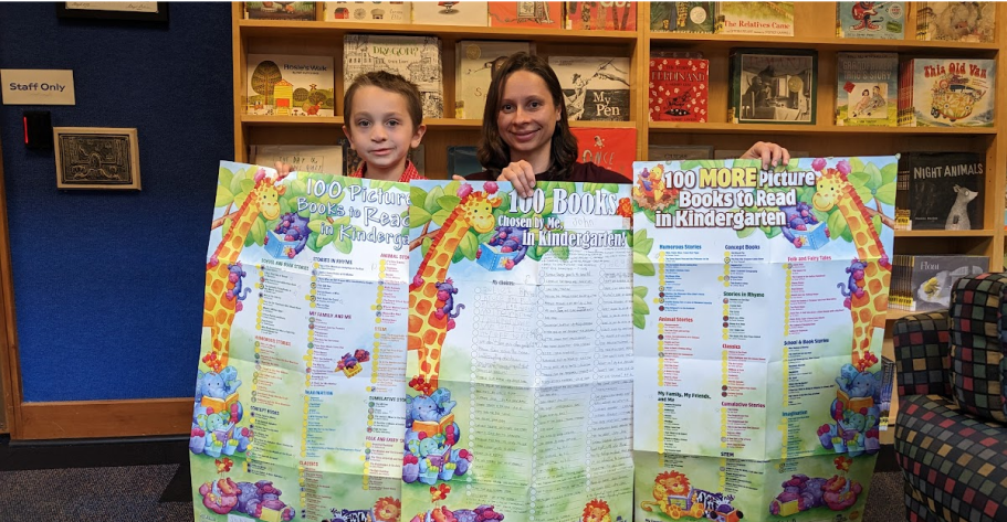 Young boy and mother holding the 100 Book challenge poster