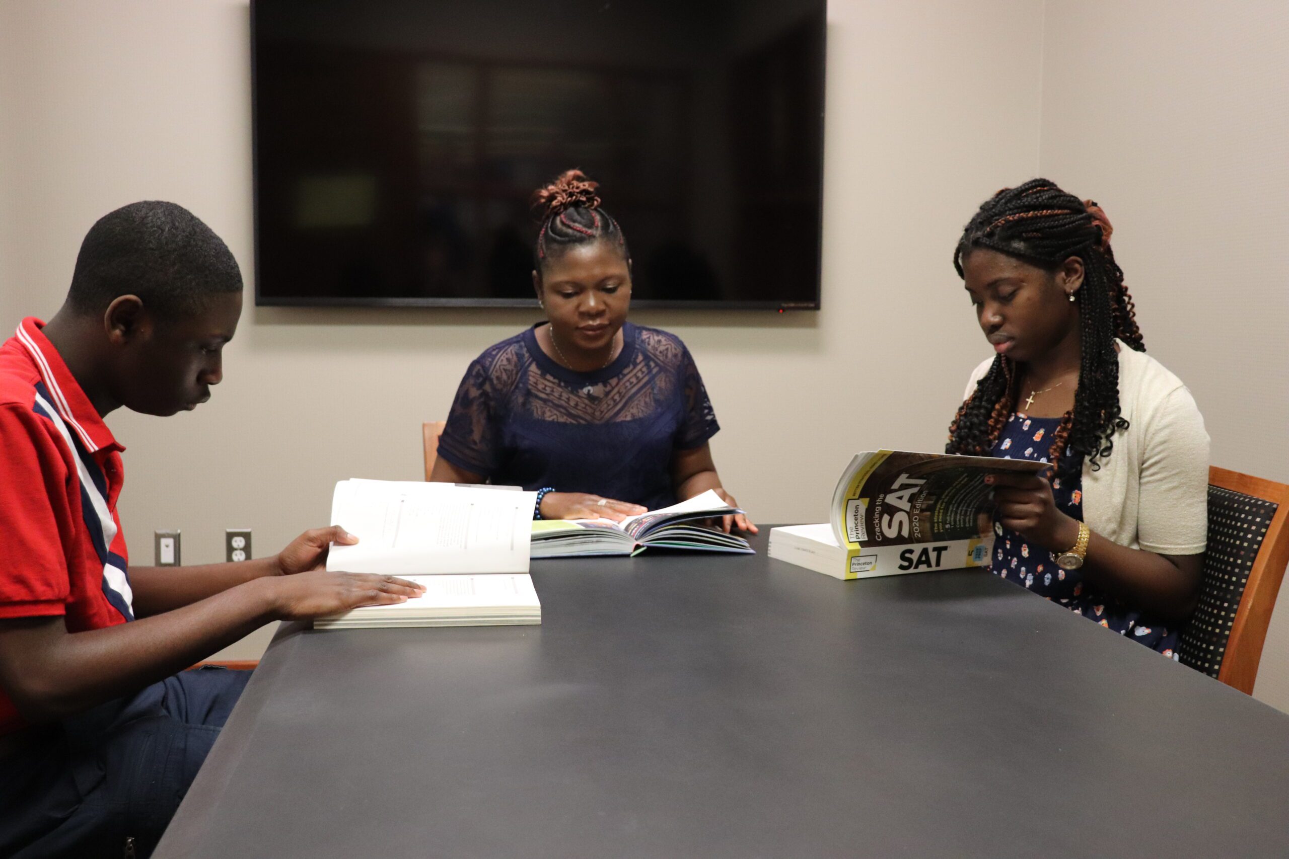 Mom and two teens reading in a study room