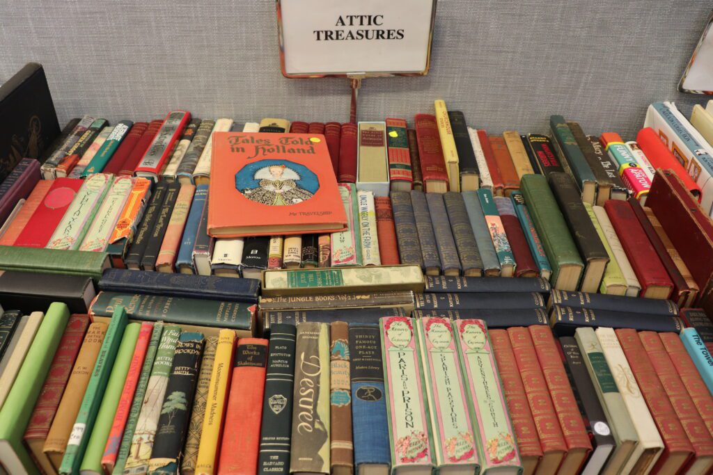 Old books on a table with a sign reading Attic Treasures