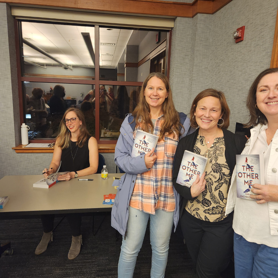 Adults holding copies of The Other Me in front of the author