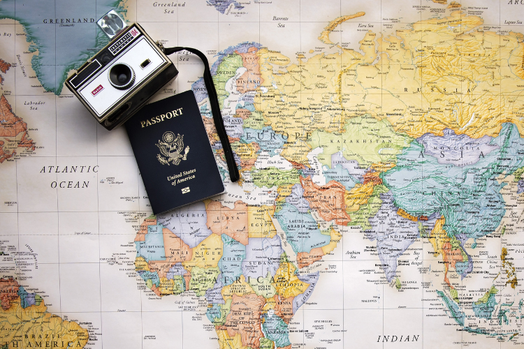 camera and passport sitting on a map