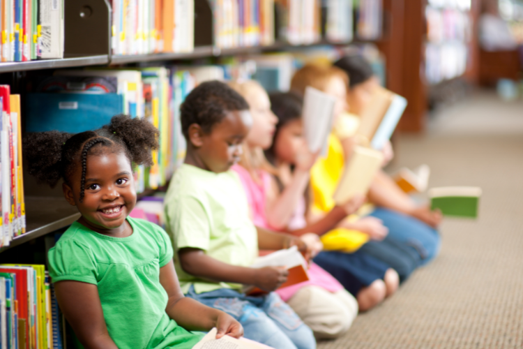 children sitting in front of a bookshelf