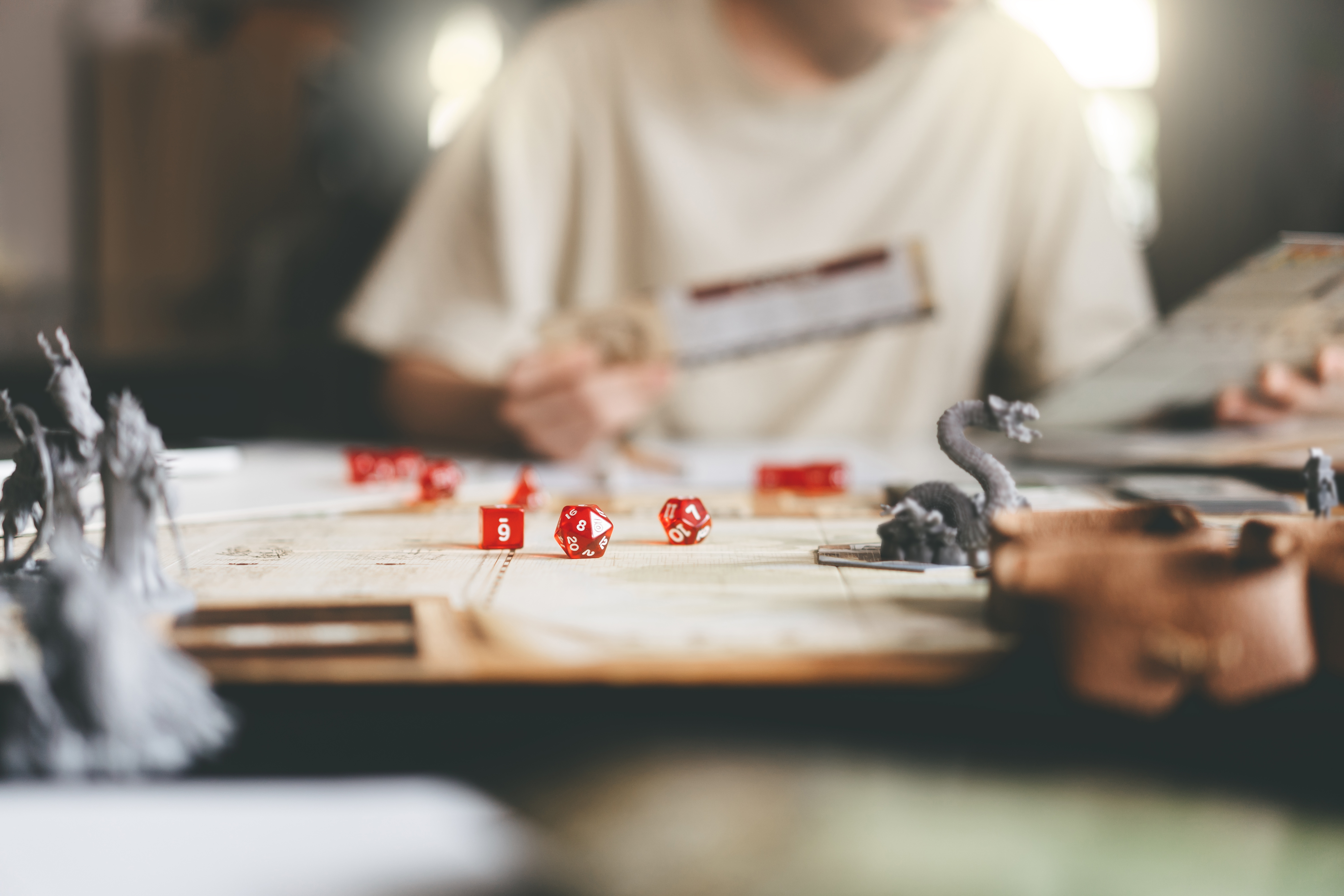 Person playing an RPG with dice and miniatures