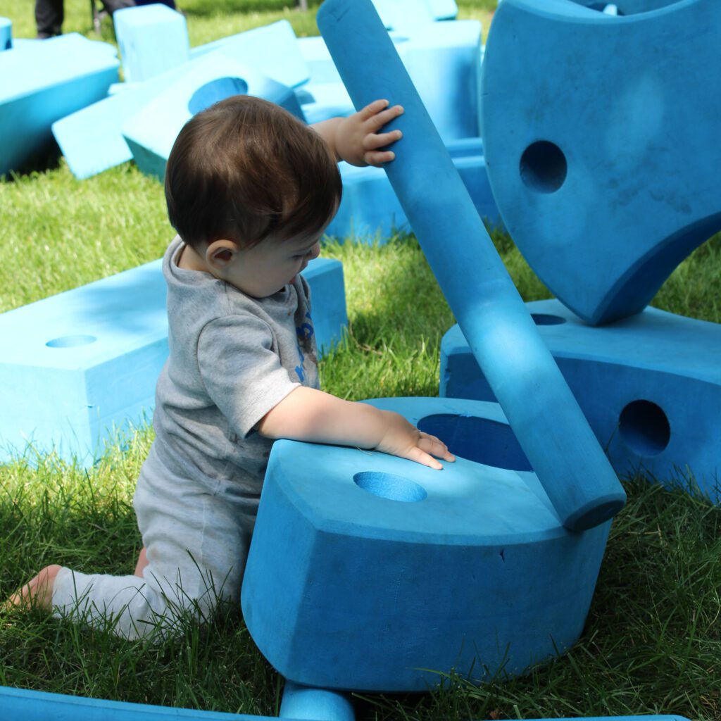 baby playing with foam blocks outside