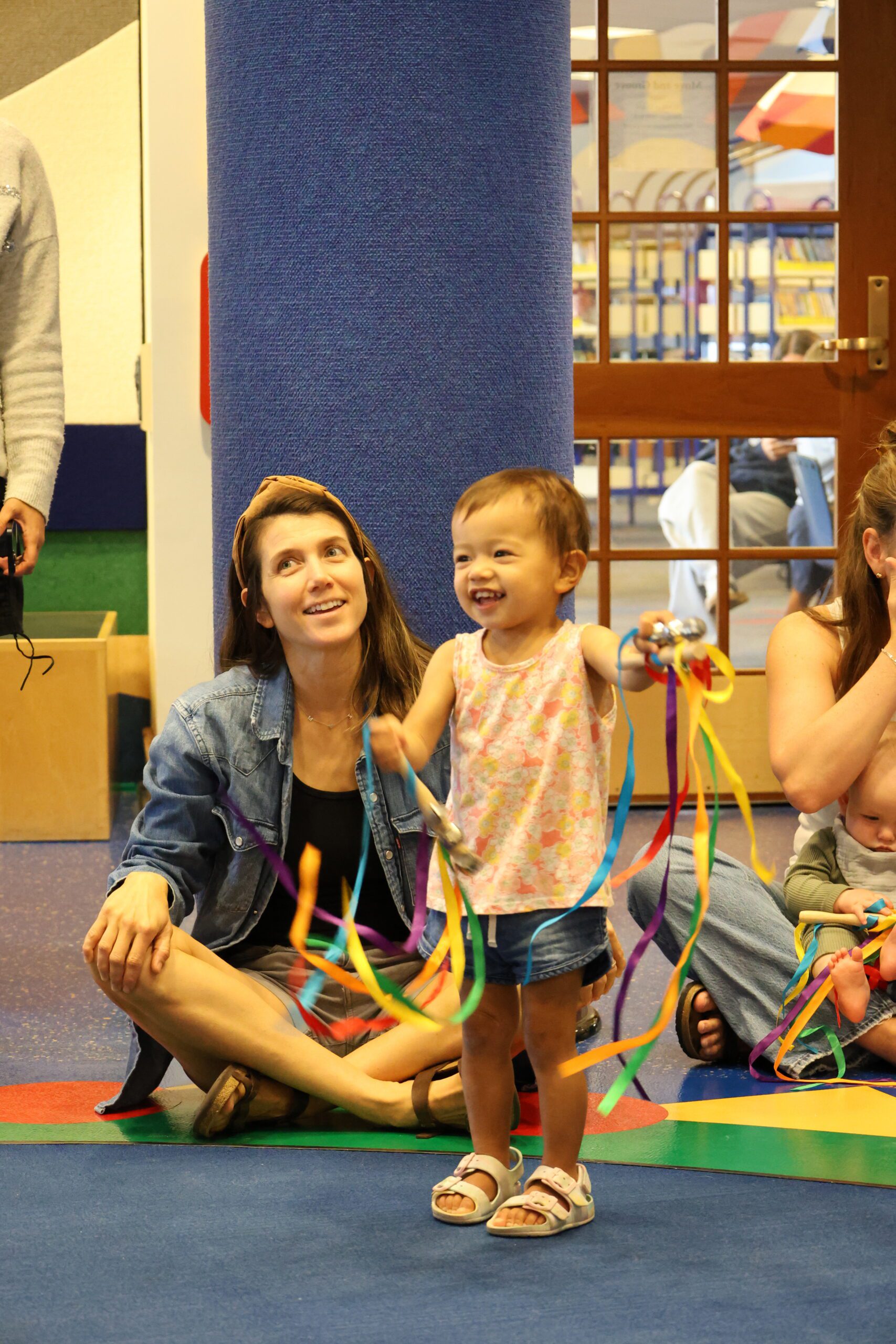 girl smiling and standing while waving ribbons
