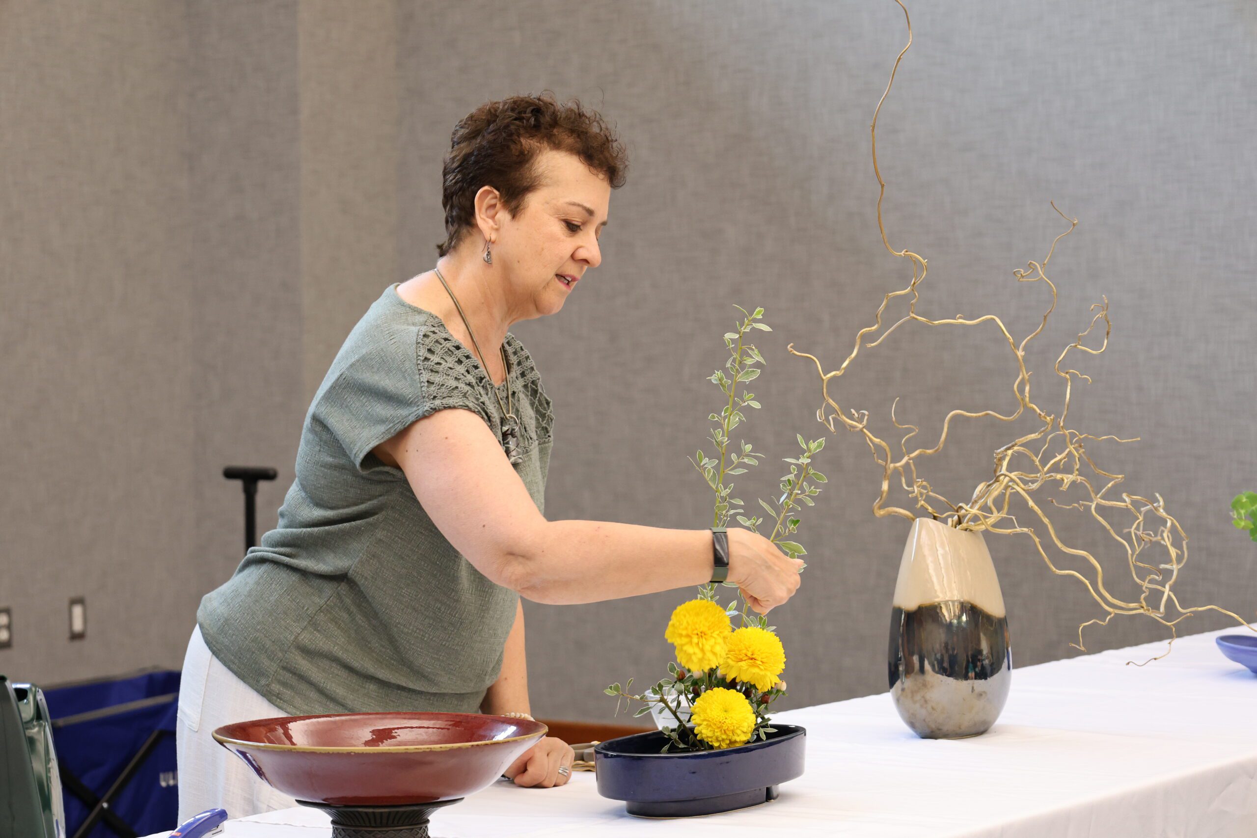 Presenter in front of flowers at Ikebana workshop