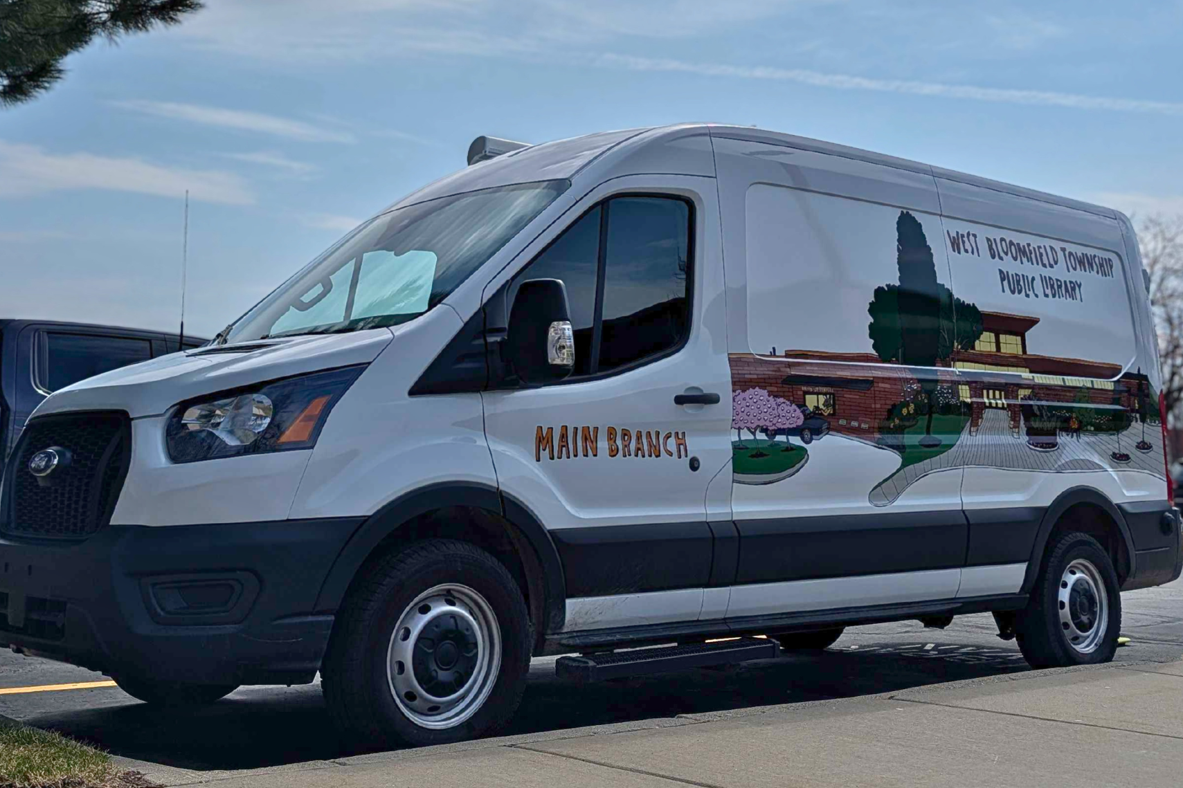 A white van with an illustration of the Main Library on the driver's side