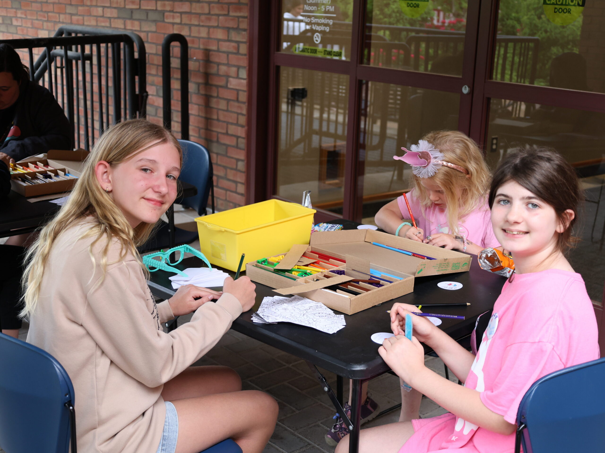 teen girls making crafts at a table outside the library