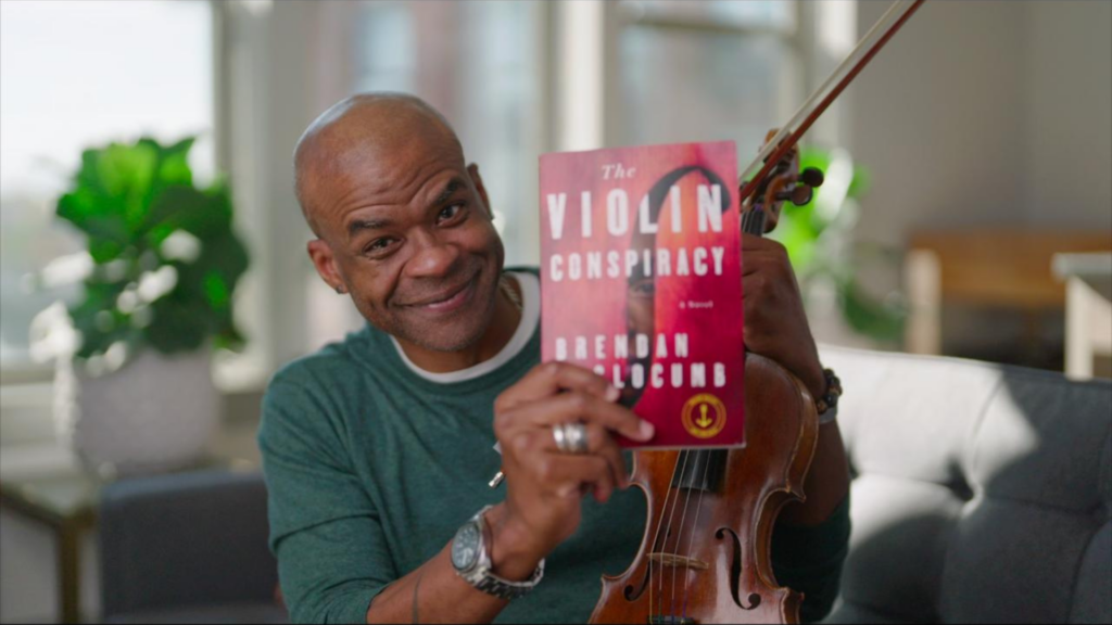 Brendan Slocumb with a violin and the book, The Violin Conspiracy